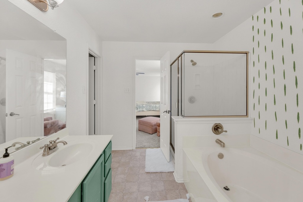 150 Mistletoe Lane Kyle, TX 78640 - Photo 18 of 35 a bathroom with a tub sink and mirror