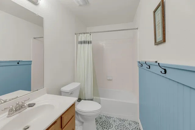 a bathroom with a sink mirror and toilet