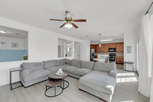 a living room with furniture and a view of kitchen