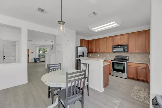 a kitchen with granite countertop a stove sink microwave and refrigerator