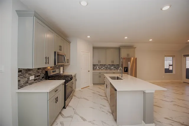 a kitchen with a sink stove and cabinets