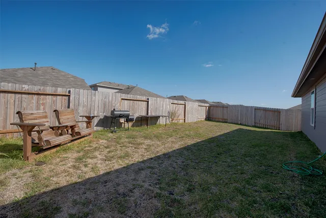 a view of a chair and fire pit in backyard of the house