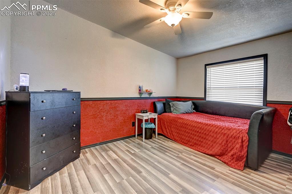 35355 Funk Road Calhan, CO 80808 - Photo 28 of 31 a bedroom with a bed and a chandelier