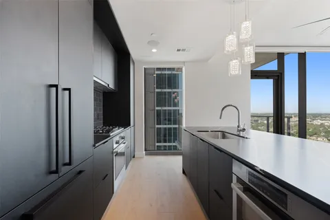 a kitchen with stainless steel appliances a sink stove and cabinets
