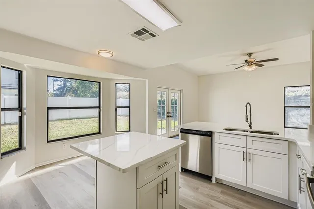 a kitchen with a stove a sink and dishwasher with wooden floor