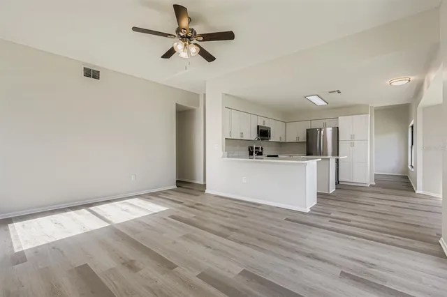 a view of kitchen with granite countertop cabinets and refrigerator