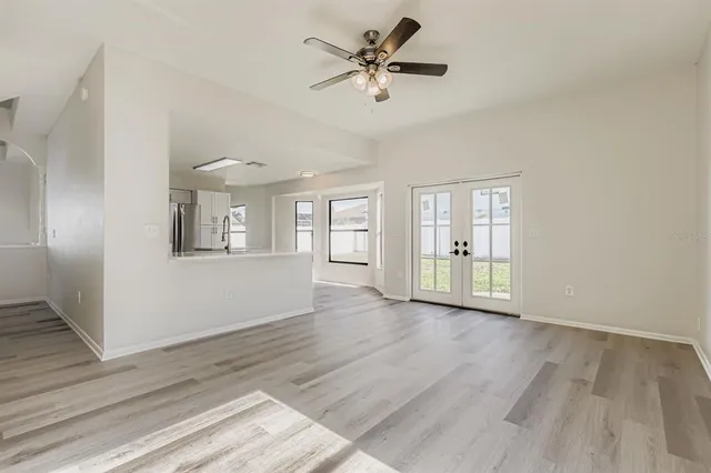 a view of an empty room with a window and wooden floor