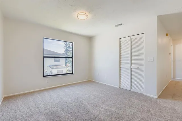 an empty room with windows and closet