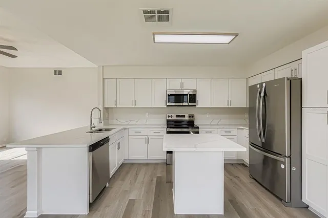 a kitchen with stainless steel appliances a refrigerator stove microwave and sink