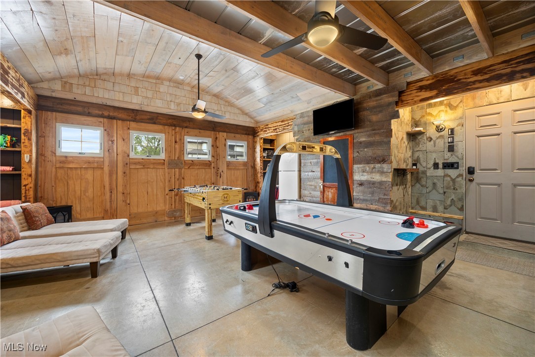 731 Cedar Point Road Sandusky, OH 44870 - Photo 41 of 50 Game room featuring wood walls, vaulted ceiling, concrete flooring, ceiling fan, and wood ceiling