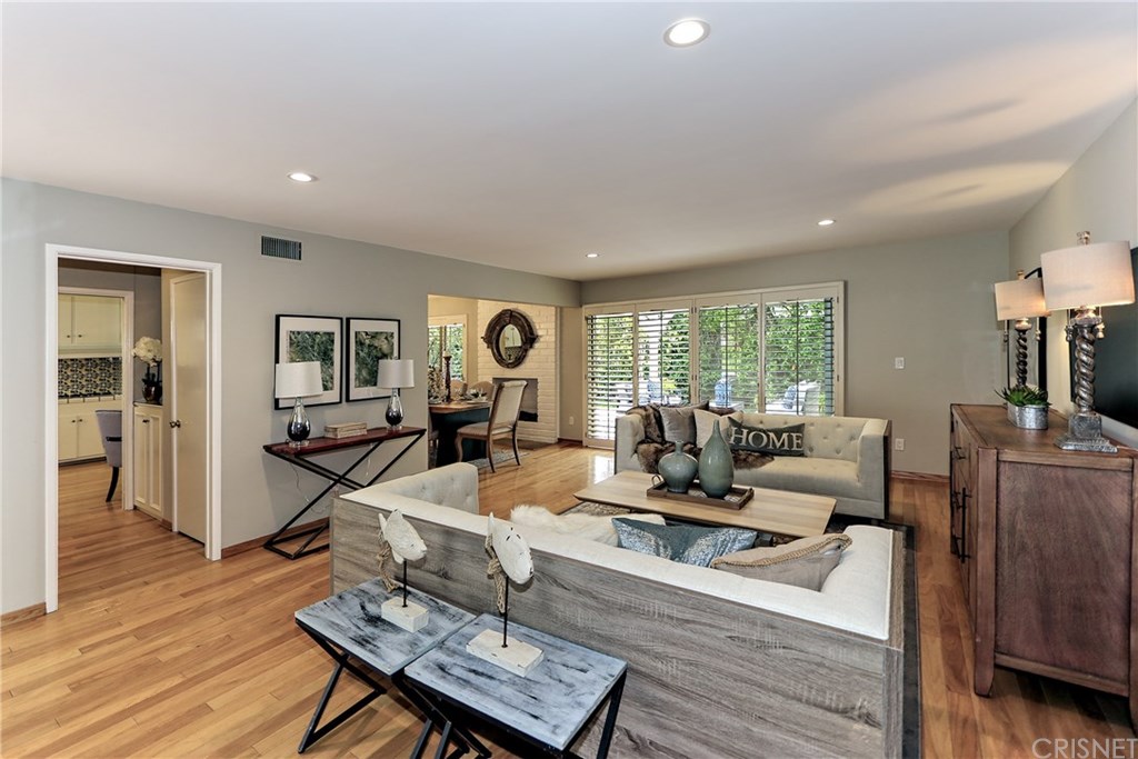 Beautiful Living Room features Newly Refinished Hardwood Floors, Recessed Lighting, Plantation Shutters and Sliding Doors overlooking Charming Rear Yard and Patio.