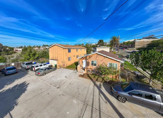 a view of building with cars parked across