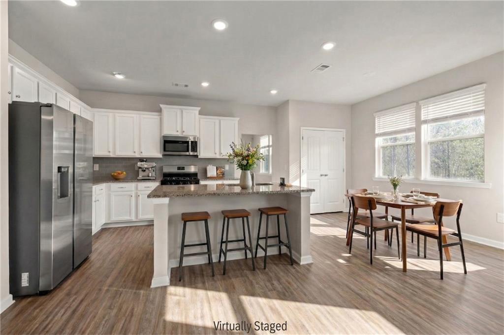 616 Hydrangea Lane Bremen, GA 30110 - Photo 3 of 49 a kitchen with stainless steel appliances granite countertop a dining table chairs refrigerator microwave and cabinets