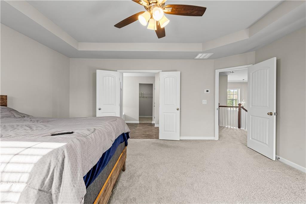 616 Hydrangea Lane Bremen, GA 30110 - Photo 9 of 49 a spacious bedroom with a bed and a chandelier