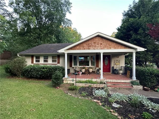 a front view of a house with garden and porch