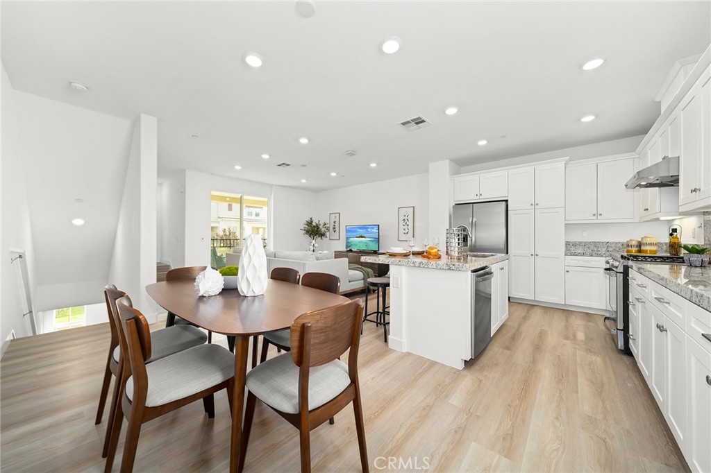 1533 St Simon Circle, Unit B Alhambra, CA 91803 - Photo 10 of 27 a kitchen with a dining table chairs and white appliances