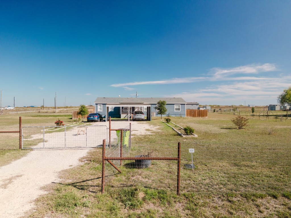 2709 County Road 463 Elgin, TX 78621 - Photo 2 of 40 View of front of property with driveway, a view of countryside, and a gate