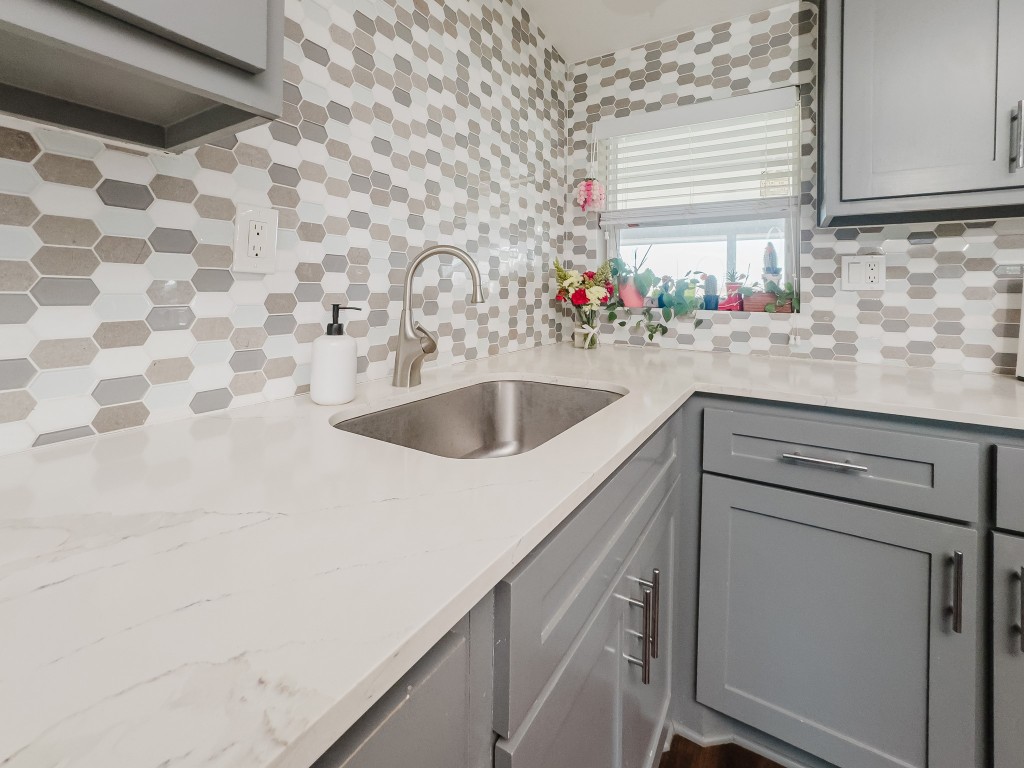 2709 County Road 463 Elgin, TX 78621 - Photo 20 of 40 Kitchen with gray cabinetry, light stone counters, and tasteful backsplash