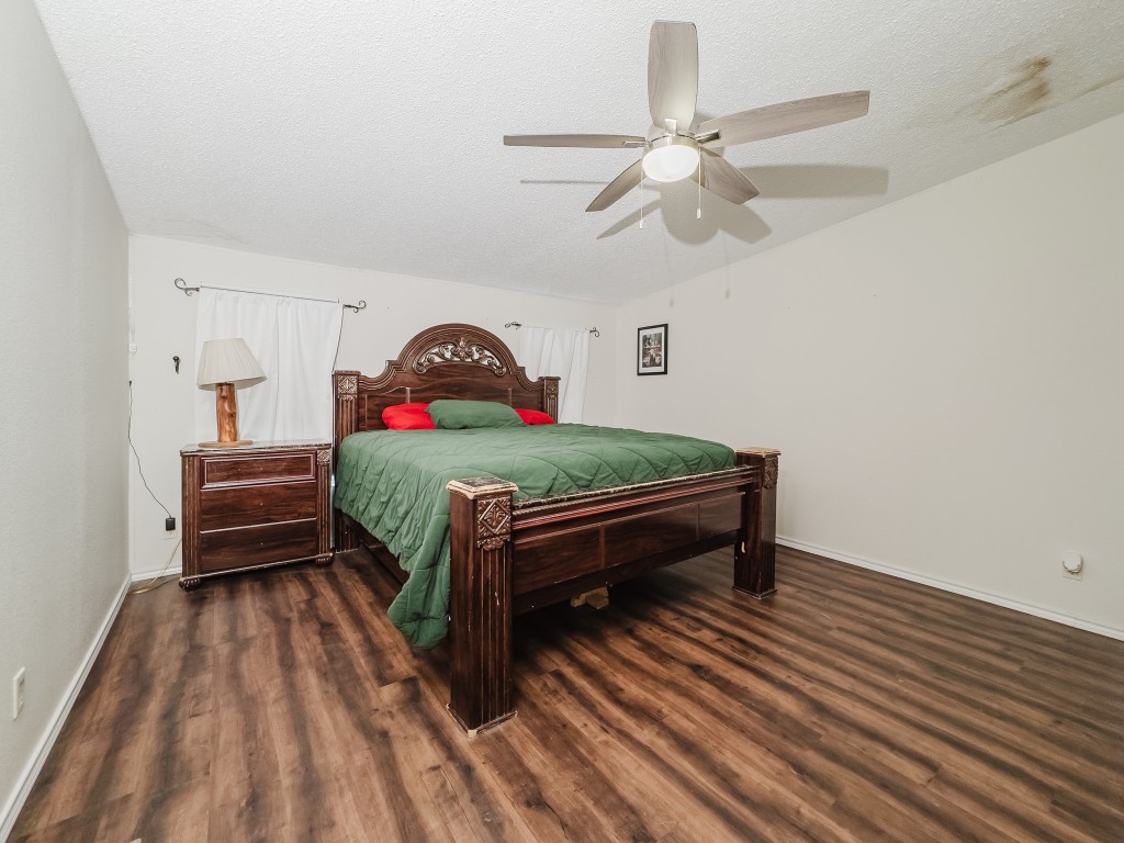 2709 County Road 463 Elgin, TX 78621 - Photo 22 of 40 Bedroom with dark wood-style flooring, ceiling fan, and a textured ceiling