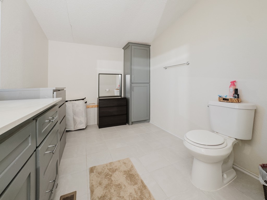 2709 County Road 463 Elgin, TX 78621 - Photo 24 of 40 Bathroom featuring vanity, light tile patterned floors, and a textured ceiling
