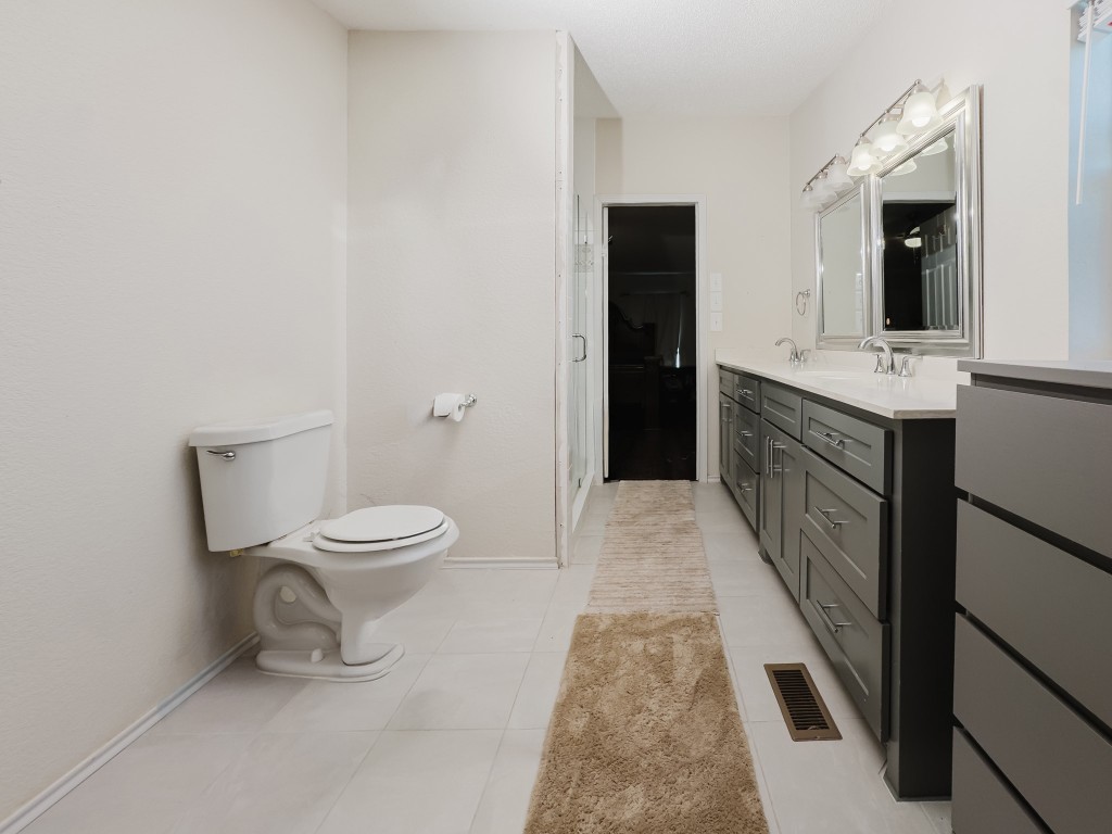 2709 County Road 463 Elgin, TX 78621 - Photo 25 of 40 Bathroom featuring double vanity, light tile patterned flooring, and a spacious closet