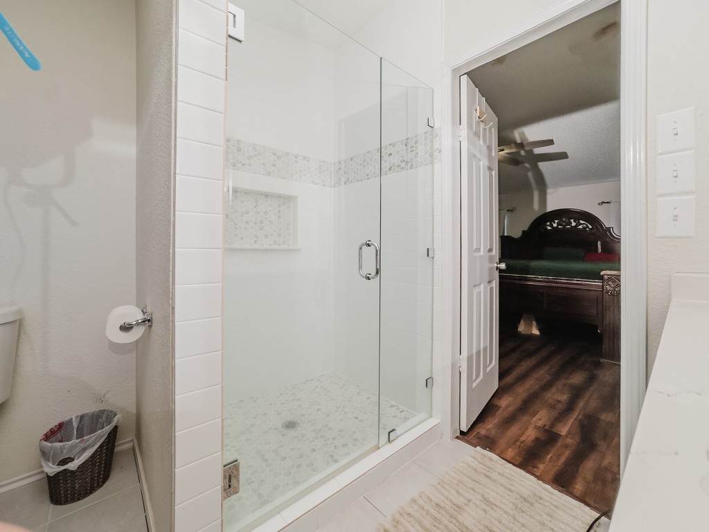 2709 County Road 463 Elgin, TX 78621 - Photo 26 of 40 Ensuite bathroom with a stall shower, tile patterned flooring, and ceiling fan
