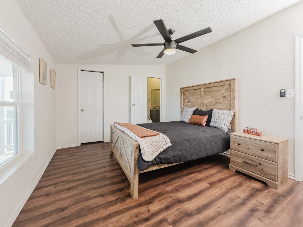 2709 County Road 463 Elgin, TX 78621 - Photo 30 of 40 Bedroom with lofted ceiling, ceiling fan, a textured ceiling, ensuite bath, and dark wood finished floors