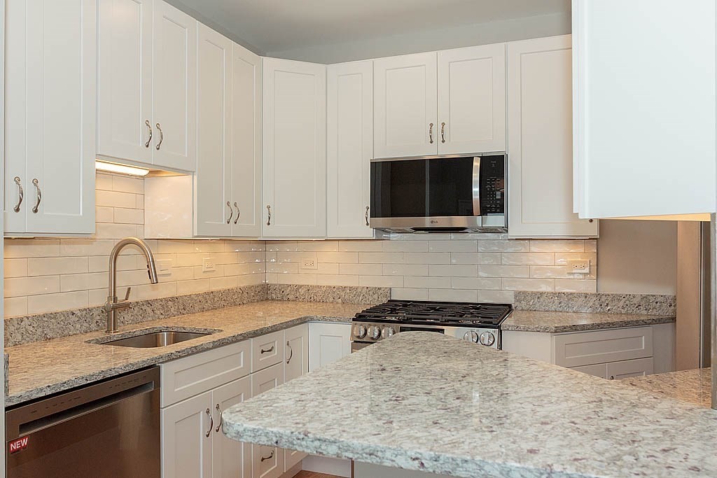 171 Walnut Street, Unit 4 Boston, MA 02122 - Photo 11 of 31 a kitchen with granite countertop a sink a stove and cabinets