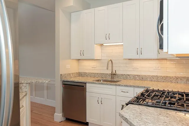 a kitchen with granite countertop white cabinets and white appliances