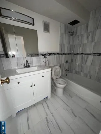 a bathroom with a double vanity sink toilet and mirror