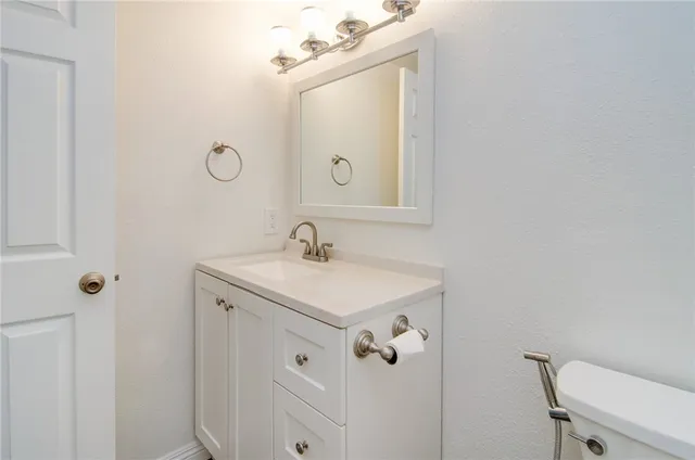 a bathroom with a sink a toilet a mirror and shower