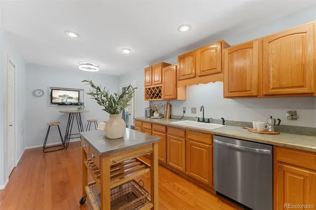 a kitchen with stainless steel appliances granite countertop a sink a stove and cabinets