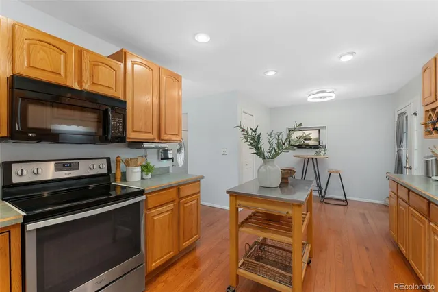 a kitchen with stainless steel appliances kitchen island granite countertop a stove a sink and a microwave