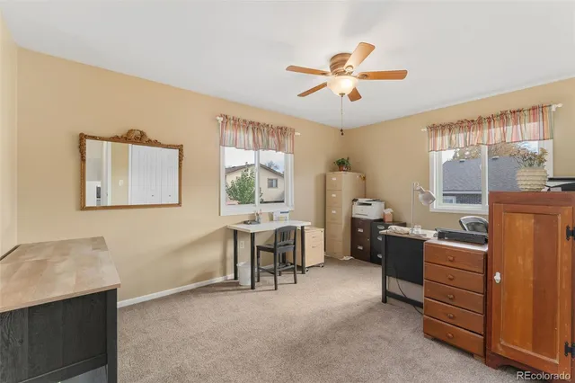 a view of a workspace with furniture and a window