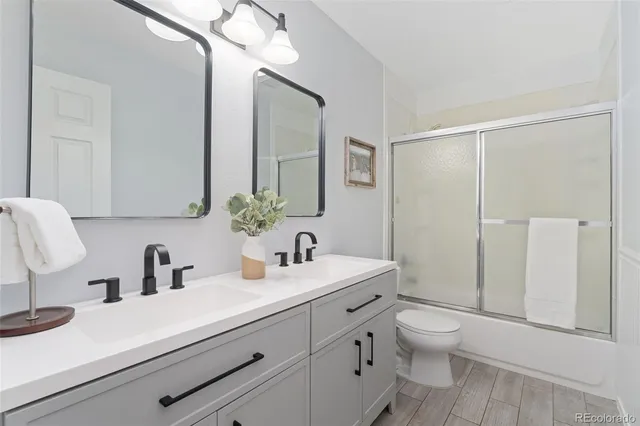 a bathroom with a sink a toilet a shower and a mirror