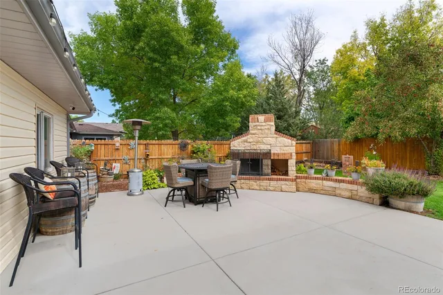 a view of a patio with table and chairs potted plants and a large tree