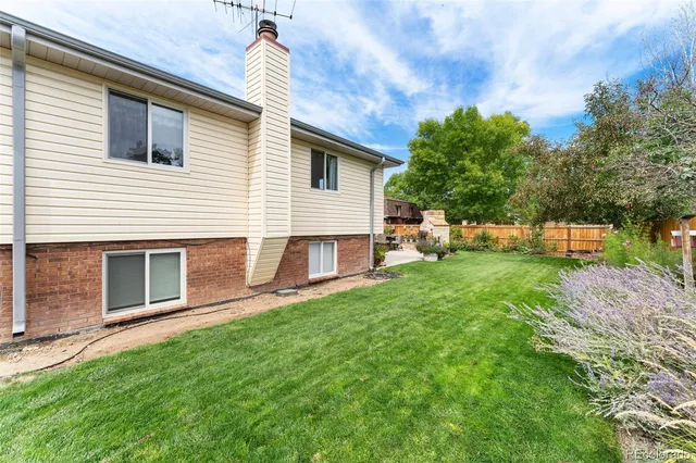 a backyard of a house with table and chairs