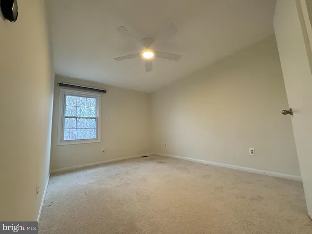 an empty room with closet and fan
