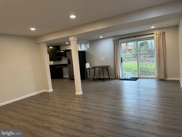 a view of an empty room with wooden floor and entryway