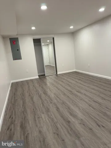 a large space with stainless steel appliances wooden floor and large window