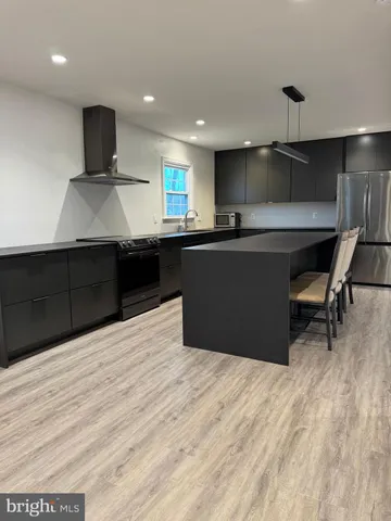 a kitchen with stainless steel appliances kitchen island sink stove and cabinets