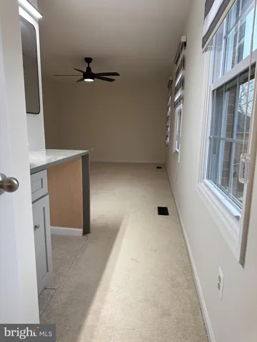 en empty room with windows and ceiling fan