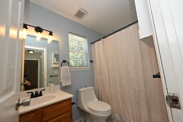 a bathroom with a toilet a sink and a mirror
