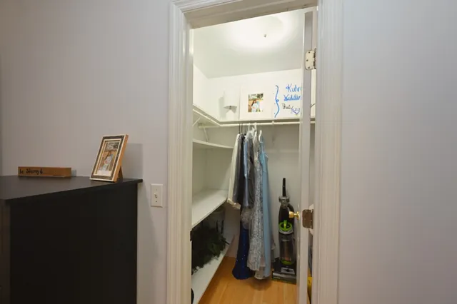 a view of walk in closet with clothes and shoes