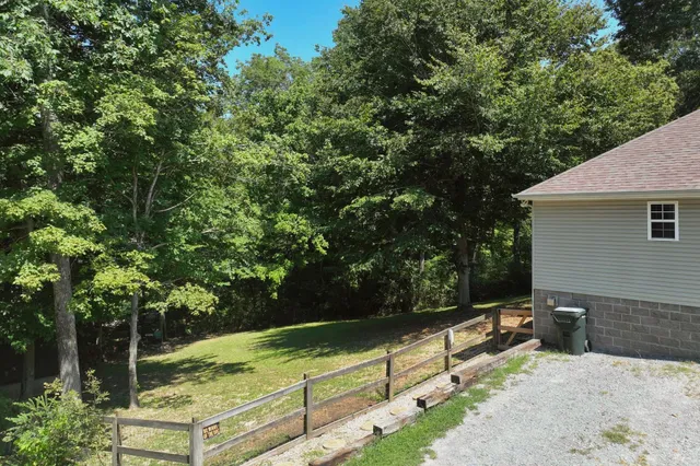 a view of a backyard with wooden fence