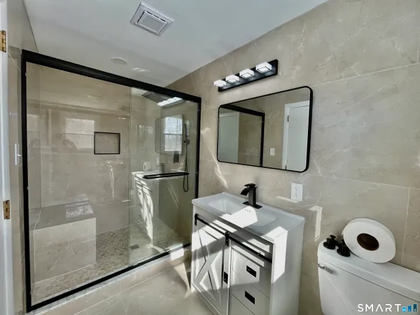 a bathroom with a sink mirror and shower
