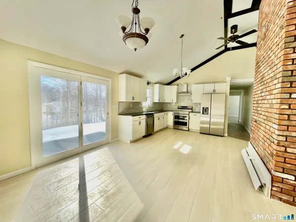 a large kitchen with a large window appliances and cabinets