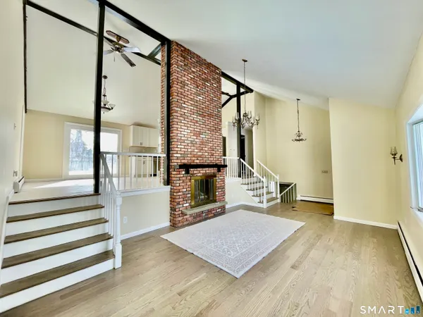a view of a hallway with wooden floor and staircase