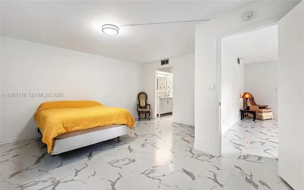 a bedroom with a bed and a view of living room