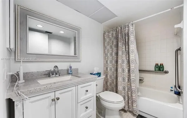 a bathroom with a granite countertop sink toilet and shower
